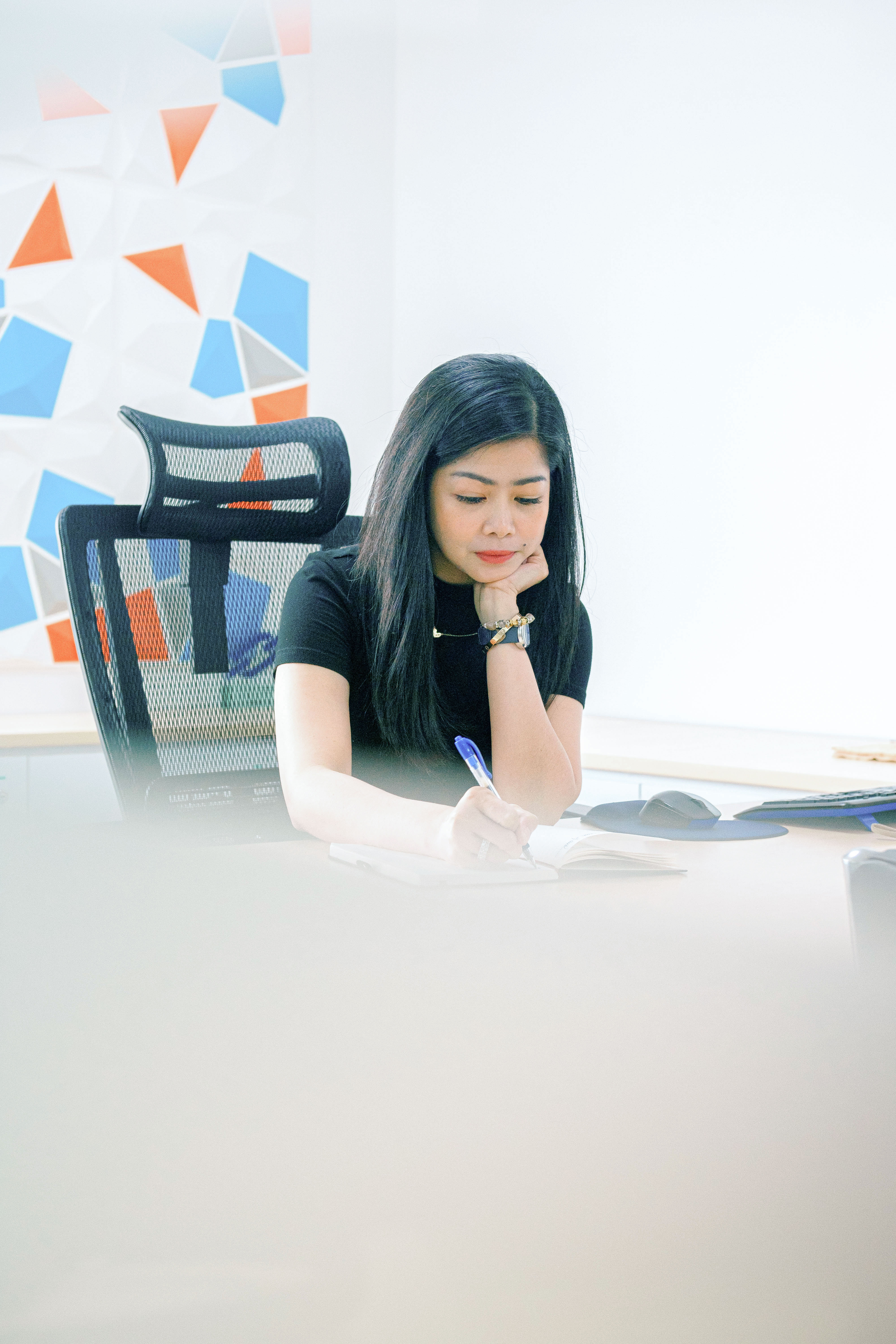 Odfjell employee writing notes at the Manila office workspace.