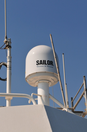 Close-up of satellite communication equipment on Odfjell tanker against clear blue sky.