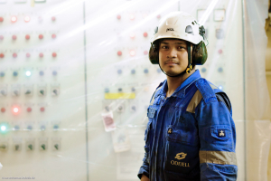 Odfjell crew member wearing safety gear in the engine control room aboard a chemical tanker.