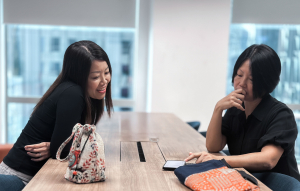 Odfjell employees collaborating at the Singapore office, reviewing information on a mobile device.