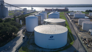Odfjell branded storage tanks at a chemical terminal with sunlight reflecting off metal surfaces.